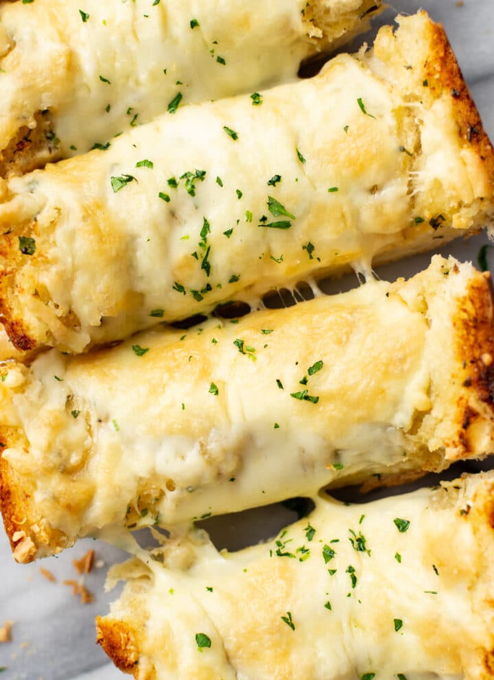 closeup of four slices of cheesy garlic bread