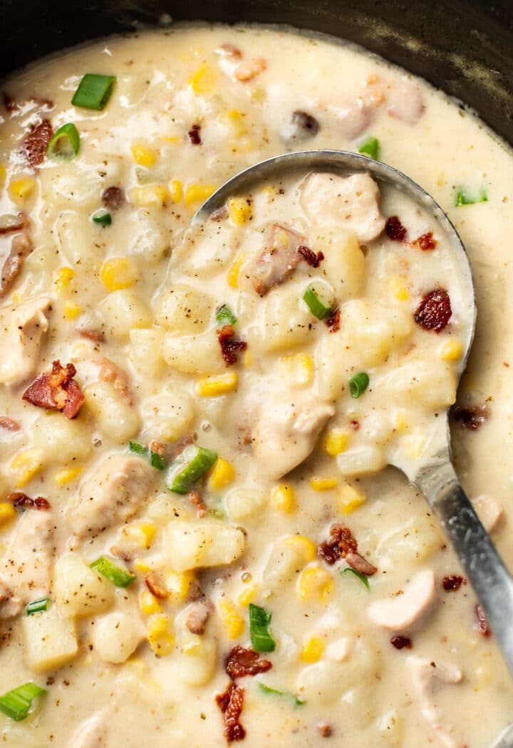 close up of a ladle of chicken and corn chowder