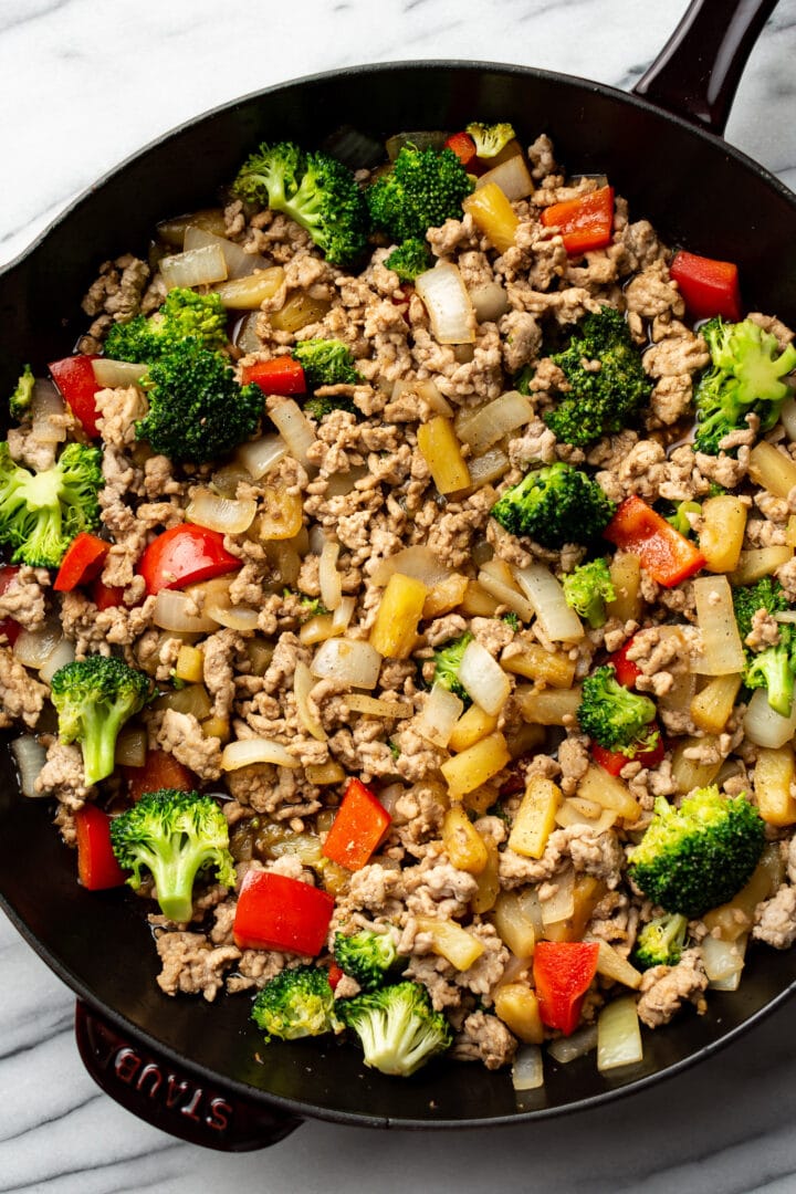 a cast iron skillet with ground pork stir fry