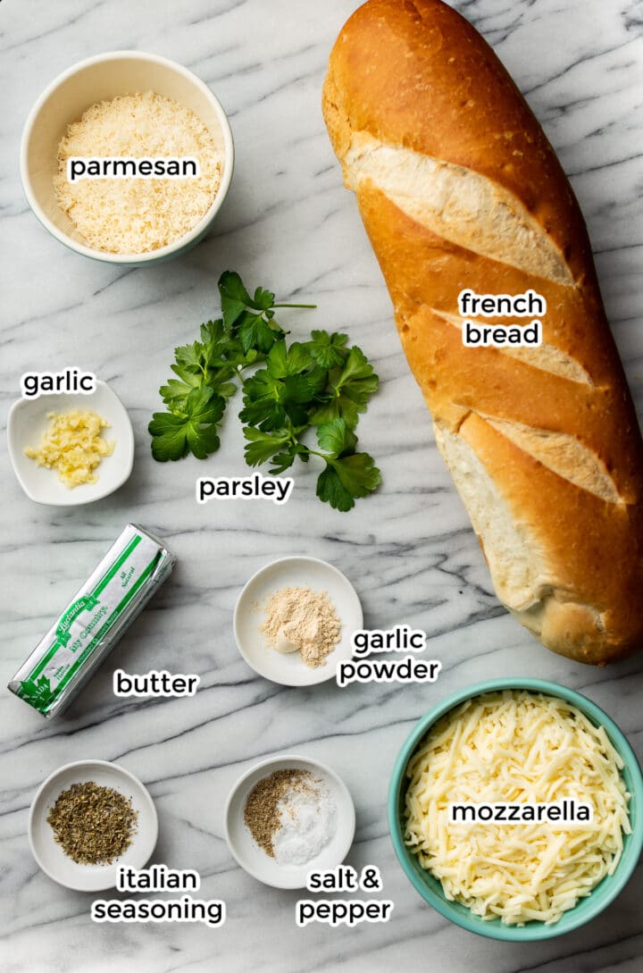 ingredients for cheesy garlic bread on a marble surface