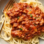 a bowl of spaghetti with meat sauce and a fork