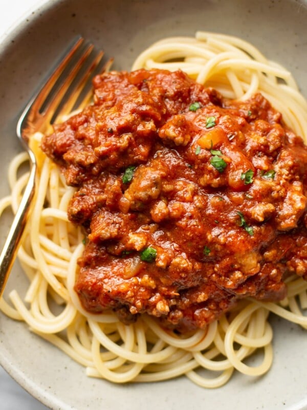 a bowl of spaghetti with meat sauce and a fork