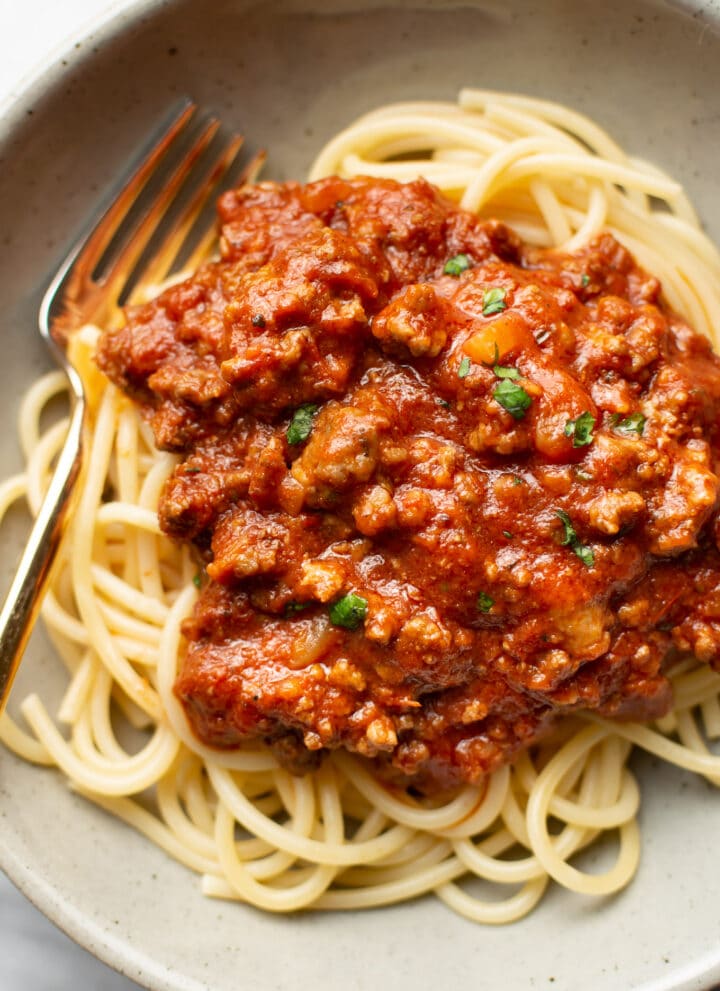 a bowl of spaghetti with meat sauce and a fork