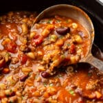 a ladle in a pot of pasta e fagioli soup