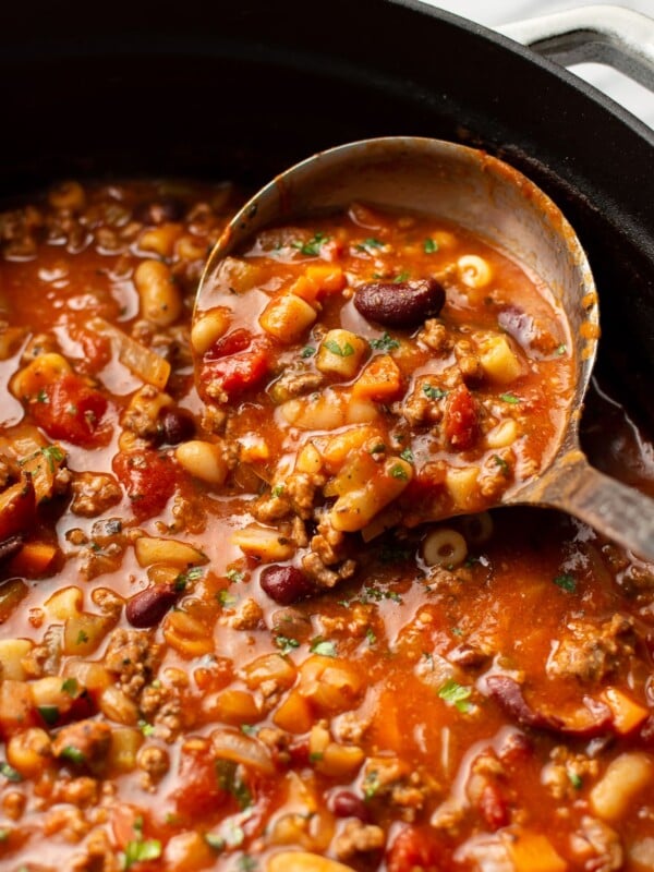 a ladle in a pot of pasta e fagioli soup