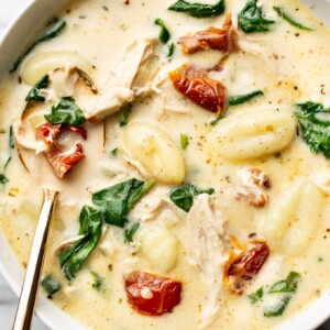 a bowl of tuscan chicken gnocchi soup with a spoon