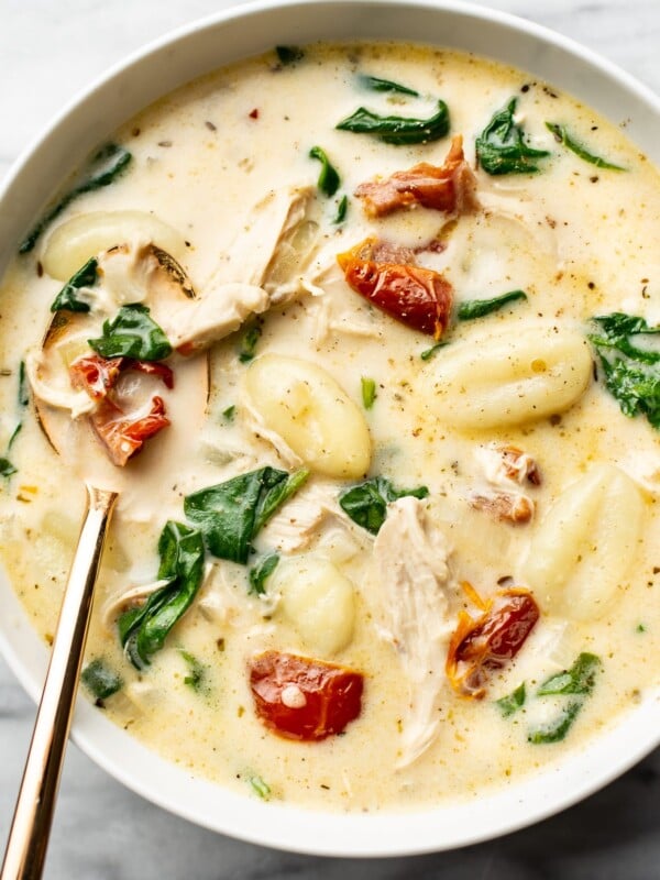 a bowl of tuscan chicken gnocchi soup with a spoon