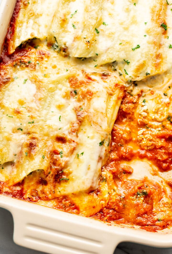 closeup of a baking dish with cheesy manicotti