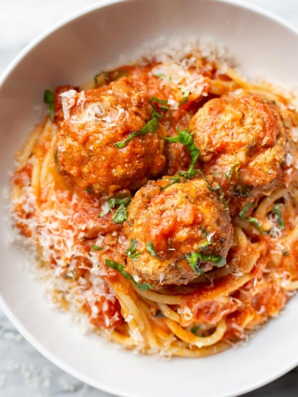 a bowl of spaghetti and meatballs with parmesan