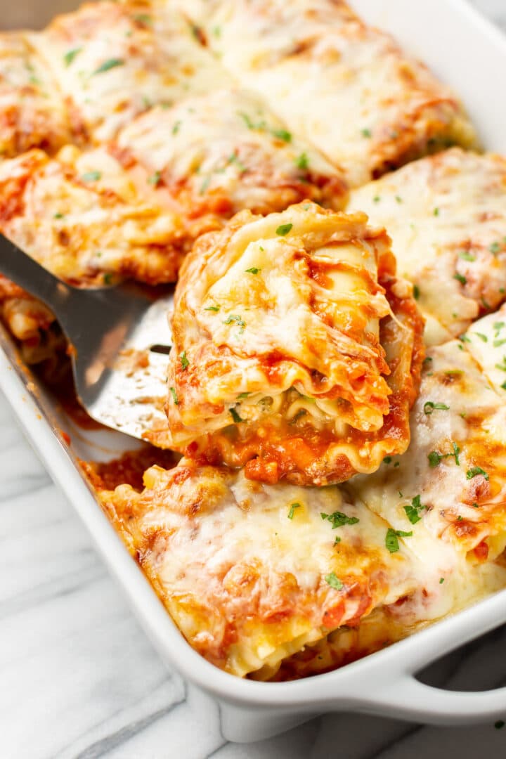 a metal spatula lifting a portion of lasagna roll ups