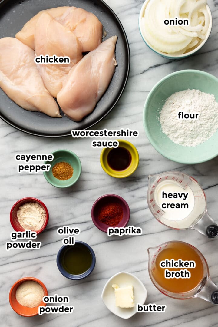 ingredients for smothered chicken in small bowls on a countertop