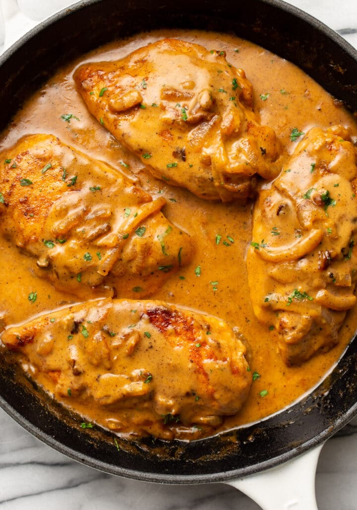 a skillet with smothered chicken