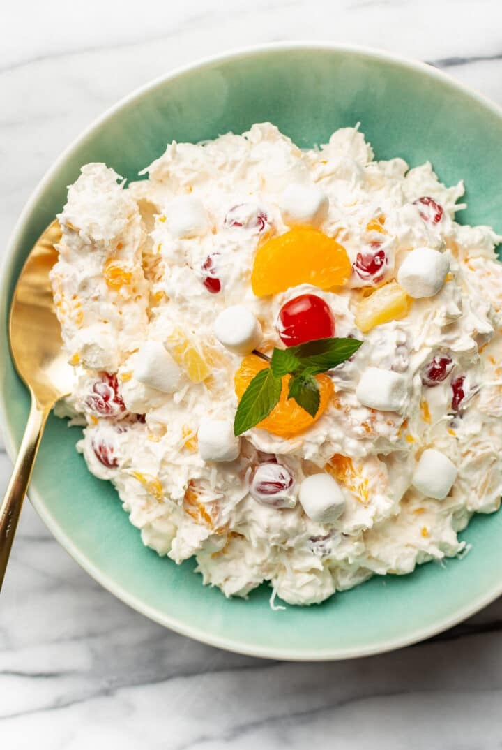 a bowl of ambrosia salad with a serving spoon