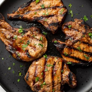 a plate with four grilled pork chops