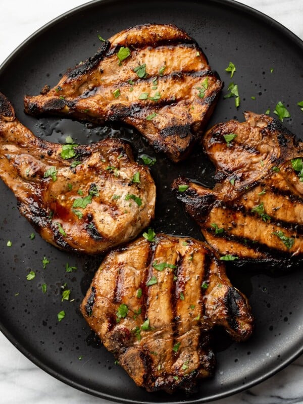 a plate with four grilled pork chops