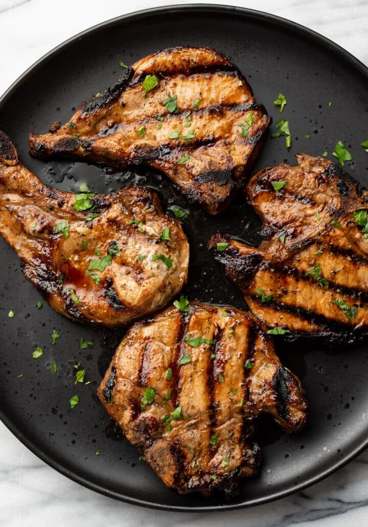 a plate with four grilled pork chops