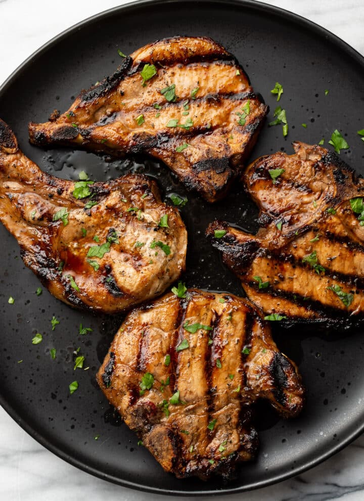a plate with four grilled pork chops