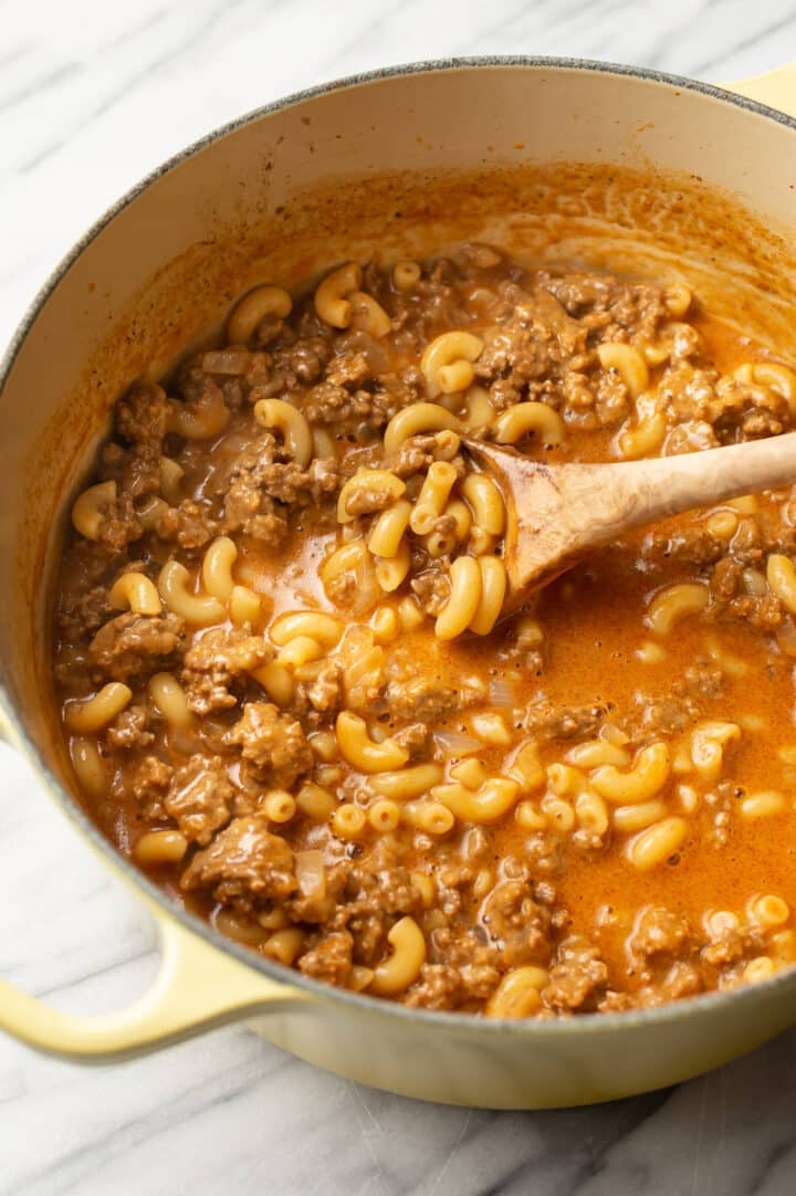 a pot of homemade hamburger helper with a wooden spoon