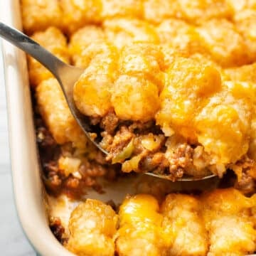 closeup of a baking dish with sloppy joe casserole and a serving spoon