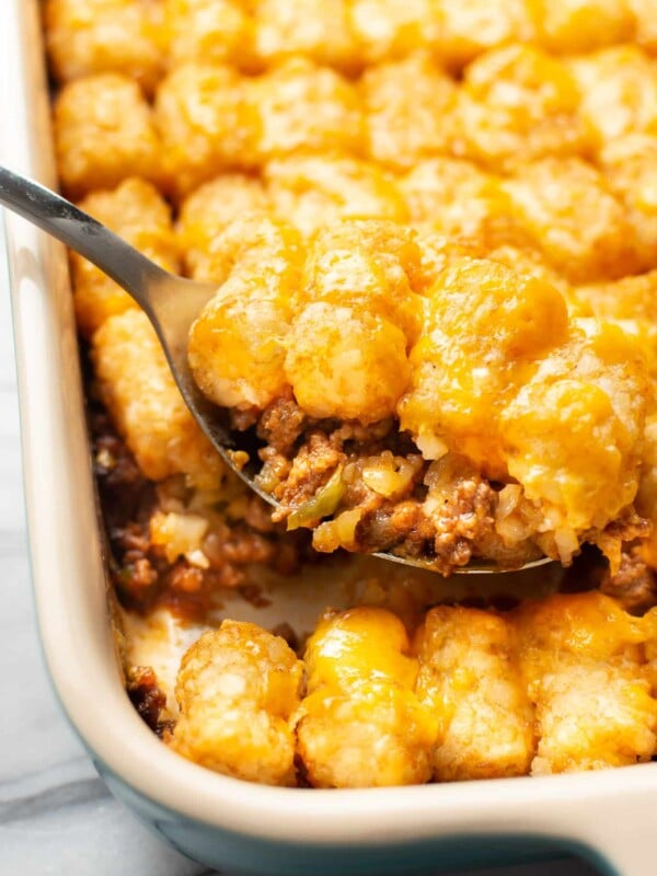 closeup of a baking dish with sloppy joe casserole and a serving spoon