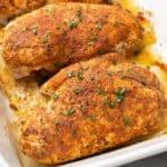 a baking dish with four baked chicken breasts