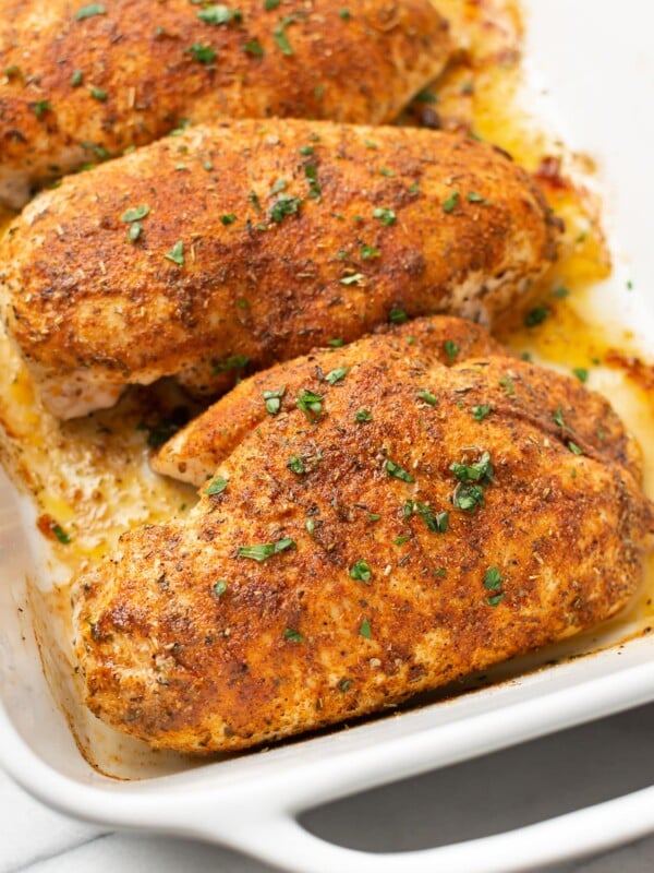 a baking dish with four baked chicken breasts
