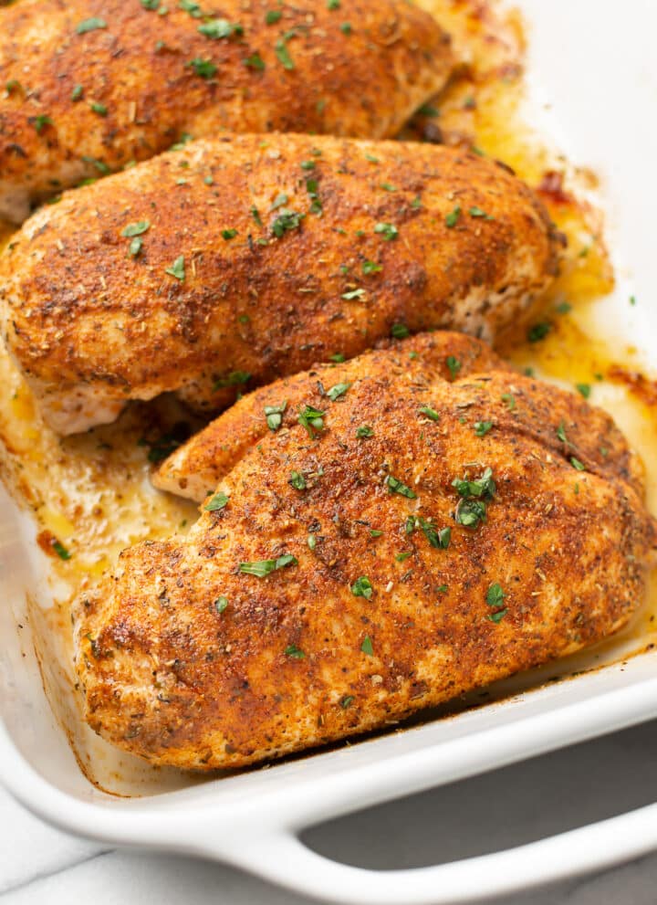 a baking dish with four baked chicken breasts