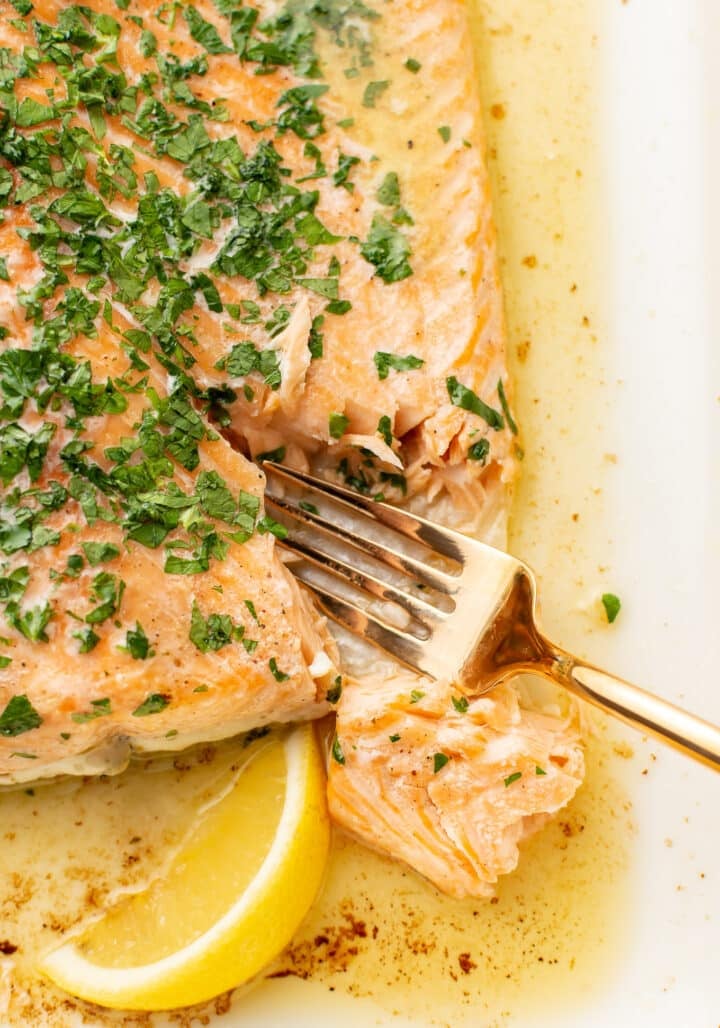 a fork flaking baked salmon