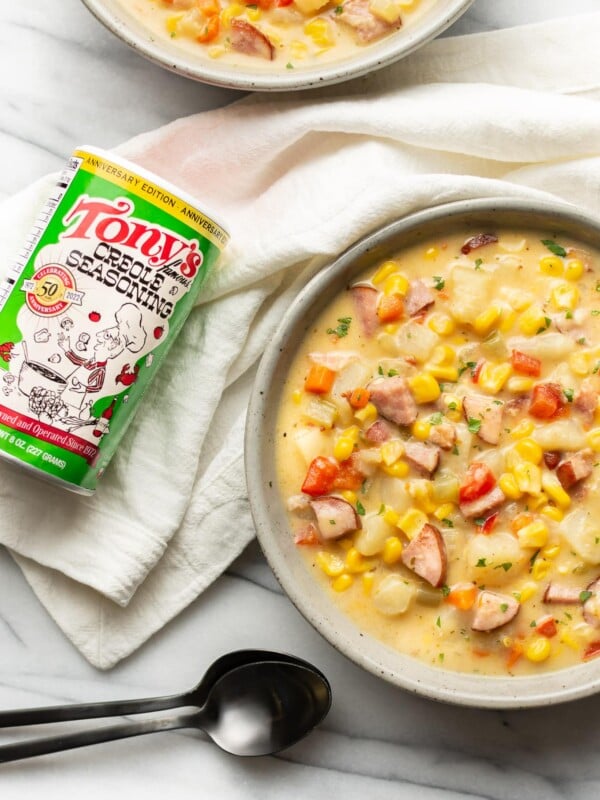 two bowls of chowder next to a can of tony chachere seasoning