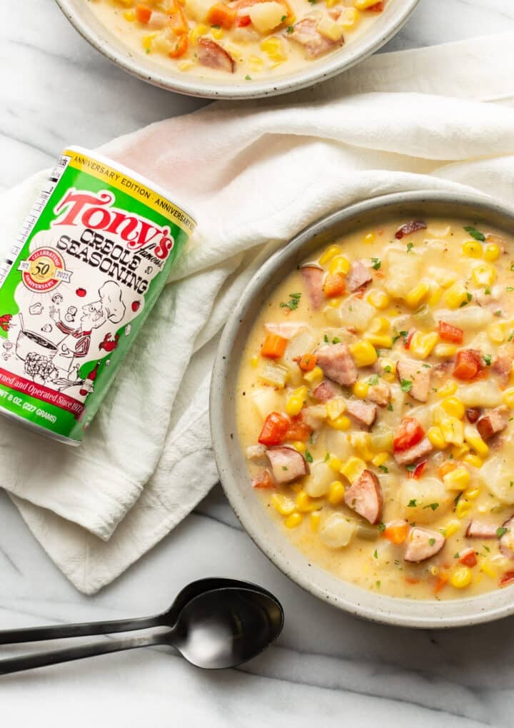 two bowls of chowder next to a can of tony chachere seasoning