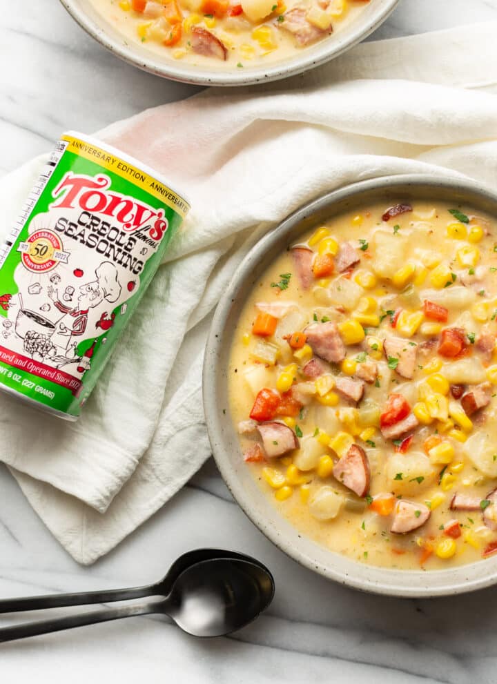 two bowls of chowder next to a can of tony chachere seasoning