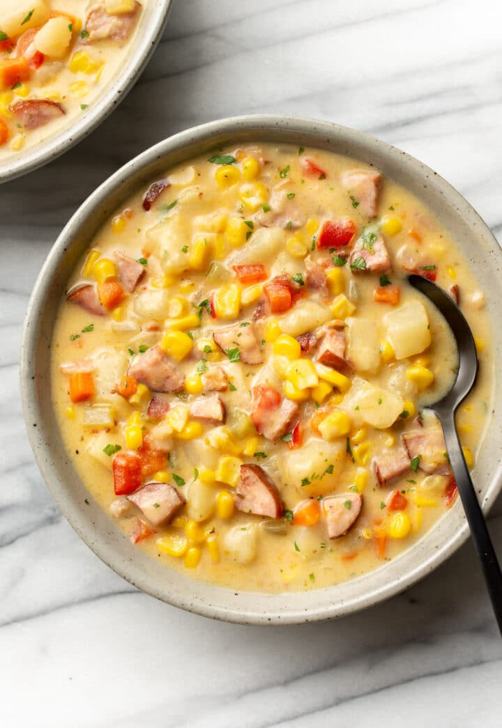 a bowl of cajun corn chowder with a spoon