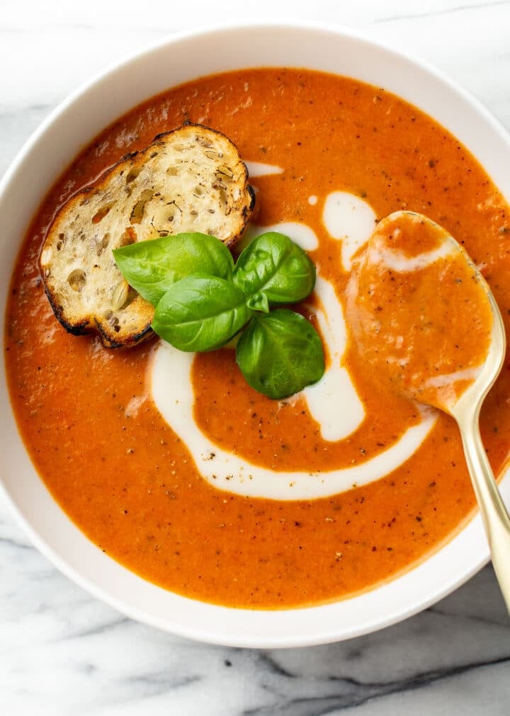 a bowl of tomato soup with a spoon