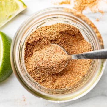 a jar with taco seasoning and a spoon