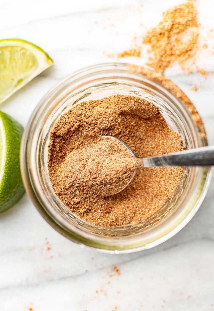 a jar with taco seasoning and a spoon