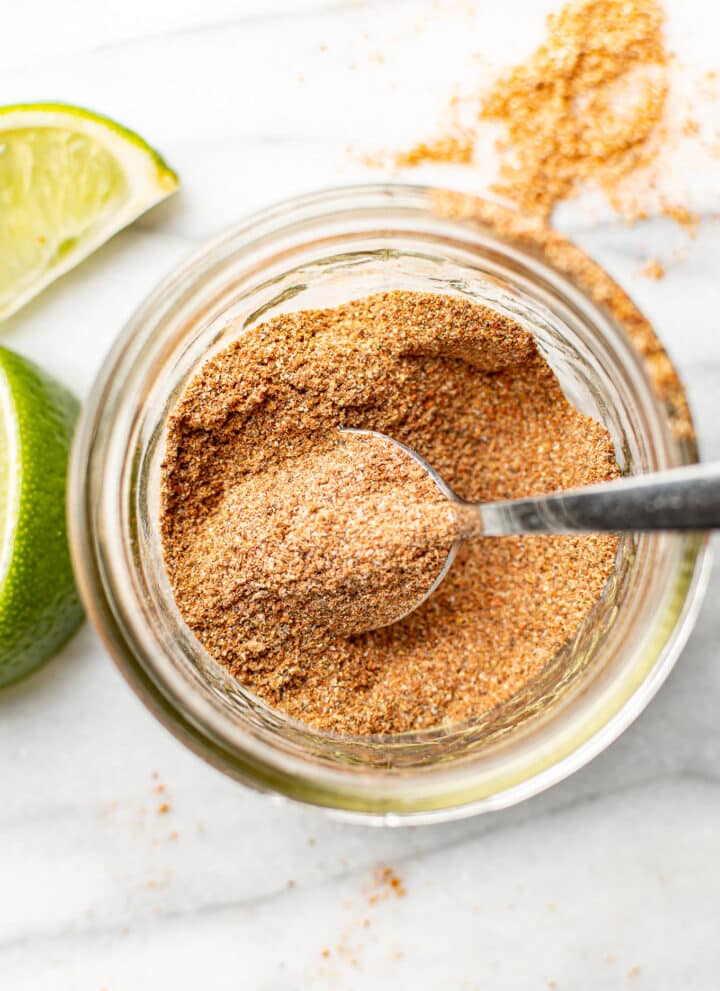 a jar with taco seasoning and a spoon