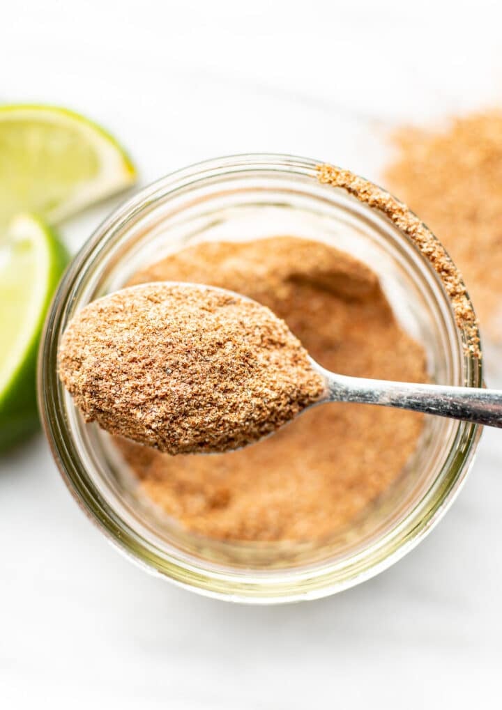 a jar of homemade taco seasoning with a spoon