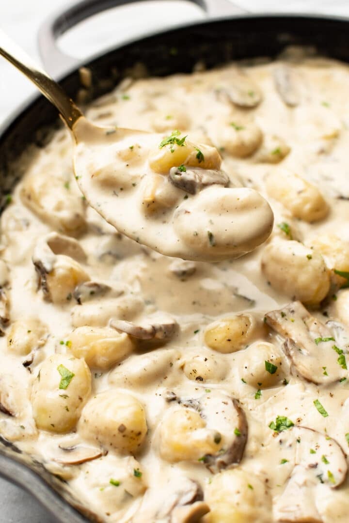 closeup of a skillet with a spoonful of creamy boursin gnocchi