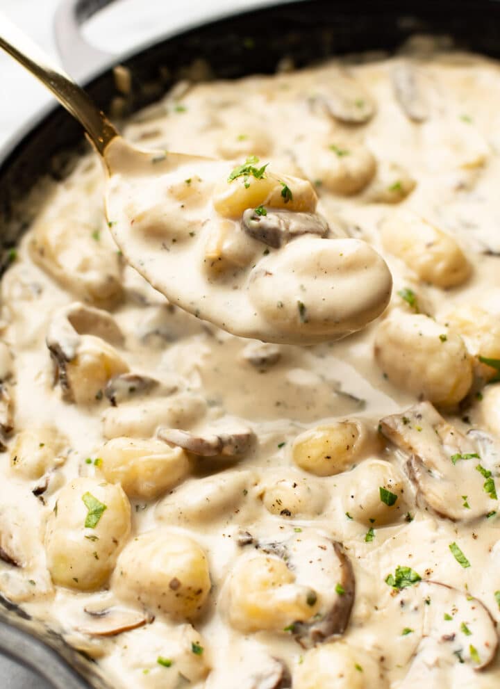 closeup of a skillet with a spoonful of creamy boursin gnocchi