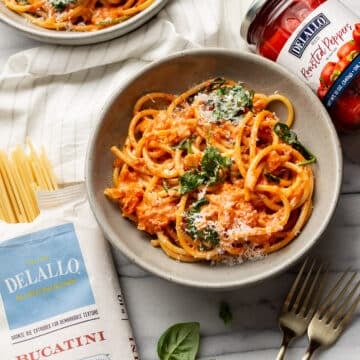 two bowls of creamy roasted red pepper pasta with delallo products