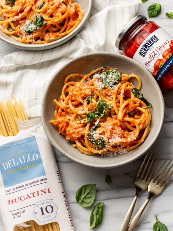 two bowls of creamy roasted red pepper pasta with delallo products