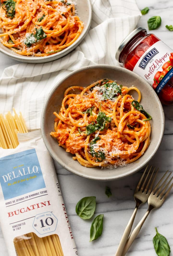 two bowls of creamy roasted red pepper pasta with delallo products