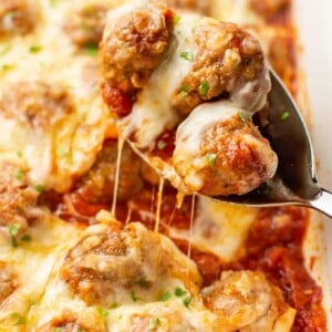 a serving spoon with cheesy baked meatballs