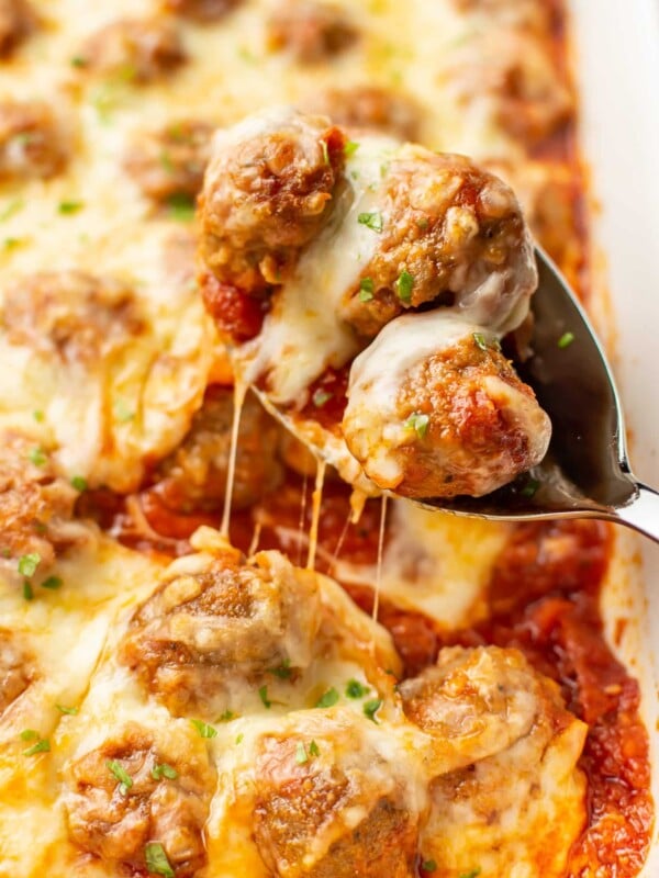 a serving spoon with cheesy baked meatballs