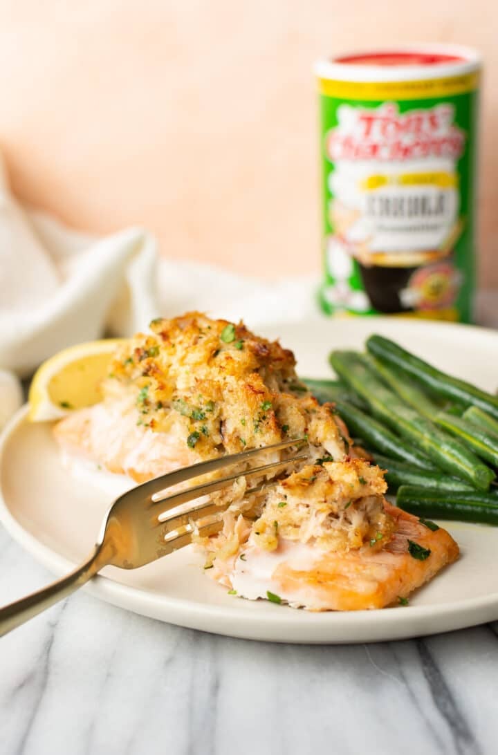 a plate of cajun stuffed salmon with a fork flaking it