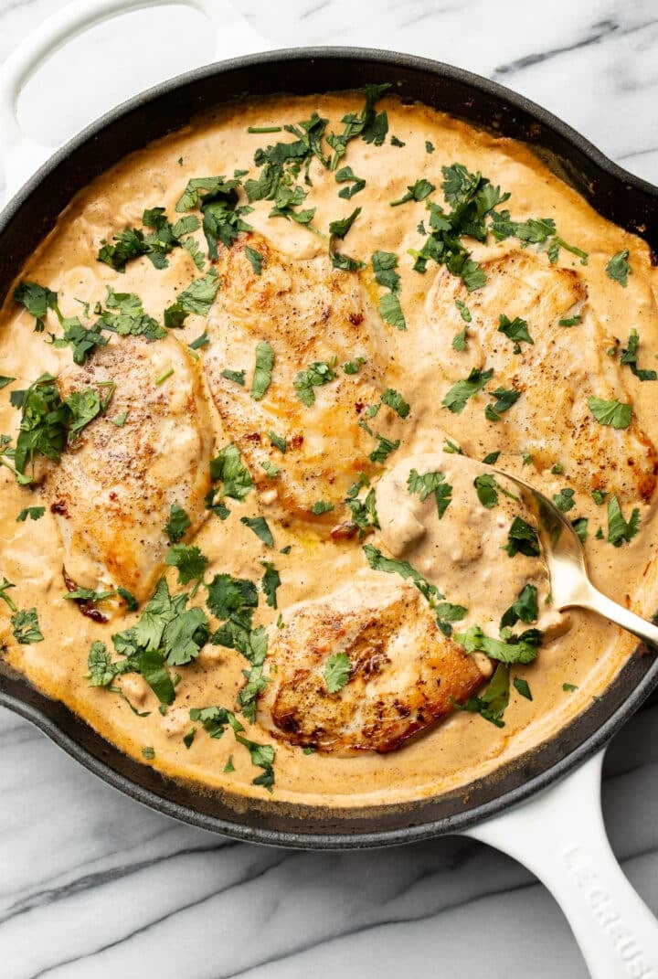 a skillet with creamy southwest chicken and a serving spoon