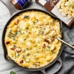 a skillet with tuscan baked gnocchi and a serving spoon