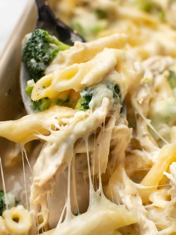 a serving spoon with chicken and broccoli alfredo bake
