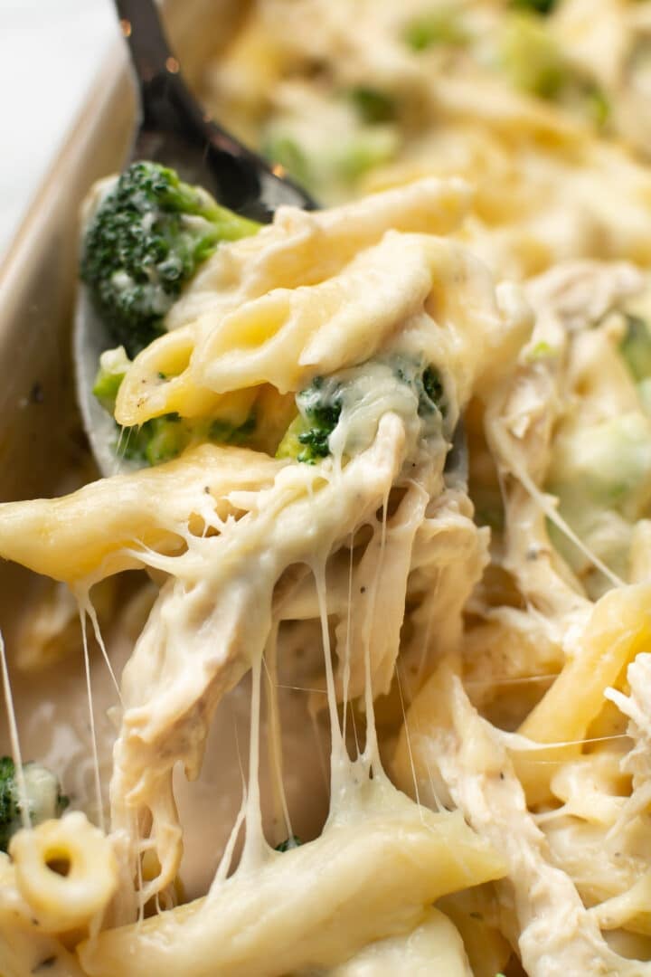 a serving spoon with chicken and broccoli alfredo bake