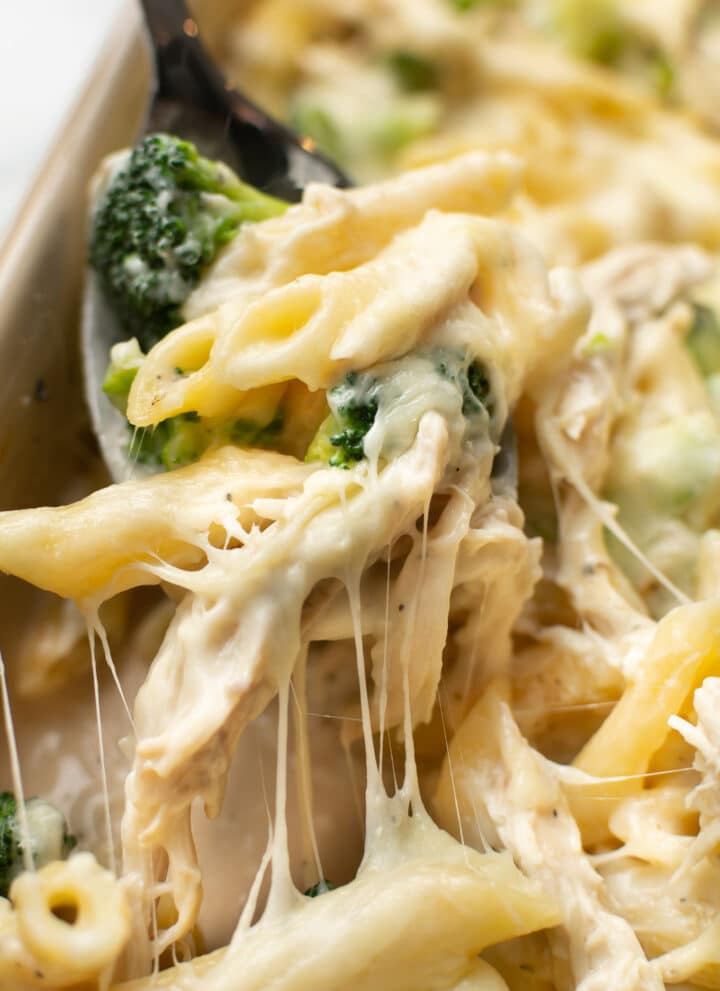 a serving spoon with chicken and broccoli alfredo bake